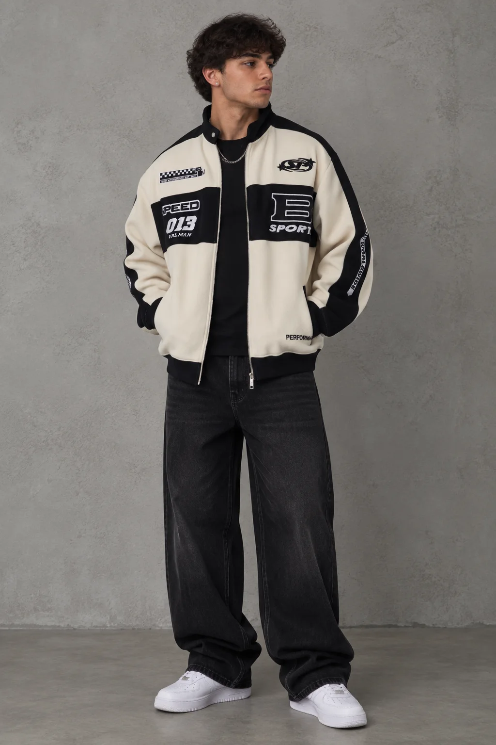 Model wearing a cream and black motorsport graphic bomber jacket